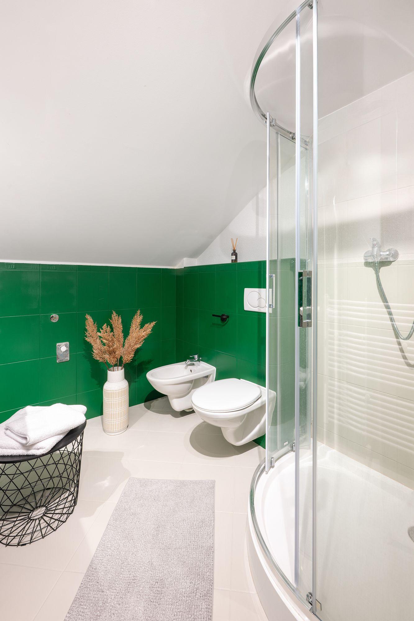 Badezimmer mit Dusche und grünen Fliesen