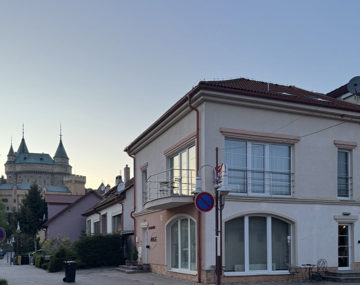 Budova Apartmánov Antré na Podzámockej ulici s Bojnickým zámkom v pozadí
